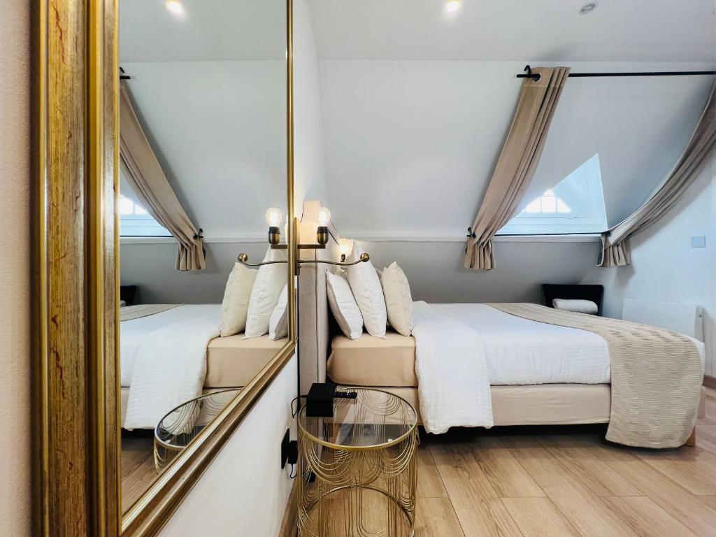 a bedroom with two beds and a mirror at Superbe appartement avec jardin et parking privé in Ris-Orangis