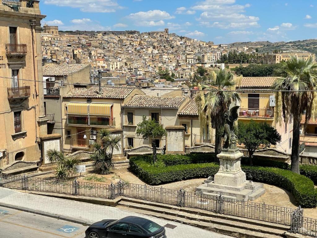 een auto geparkeerd voor een stad met gebouwen bij Il Teatrino del Bonajuto in Caltagirone
