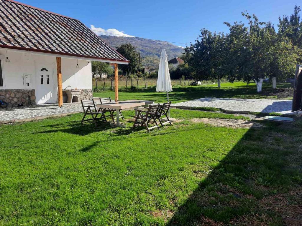 a table and chairs in a yard with a umbrella at Villa Apartments B&D in Ohrid