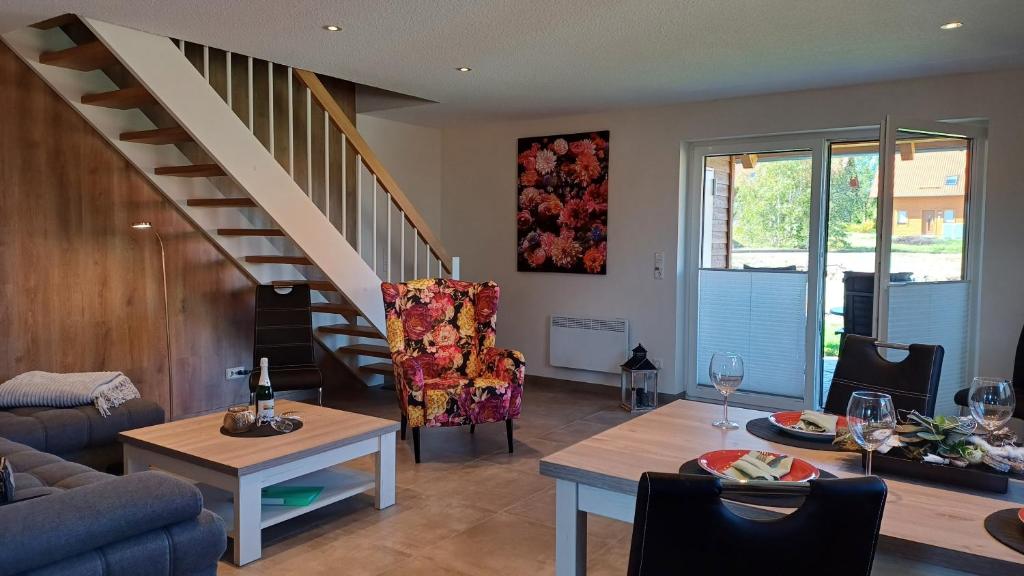 un salon avec un escalier et une table dans l'établissement Ferienhaus Kari, à Hasselfelde