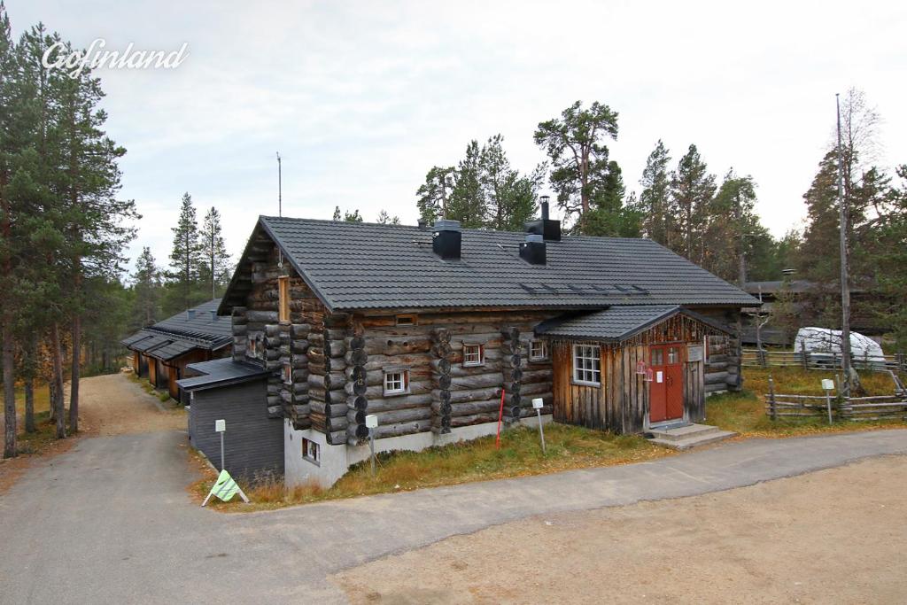 a log cabin with a red door at Kuukkeli Hirvas Suite in Saariselka