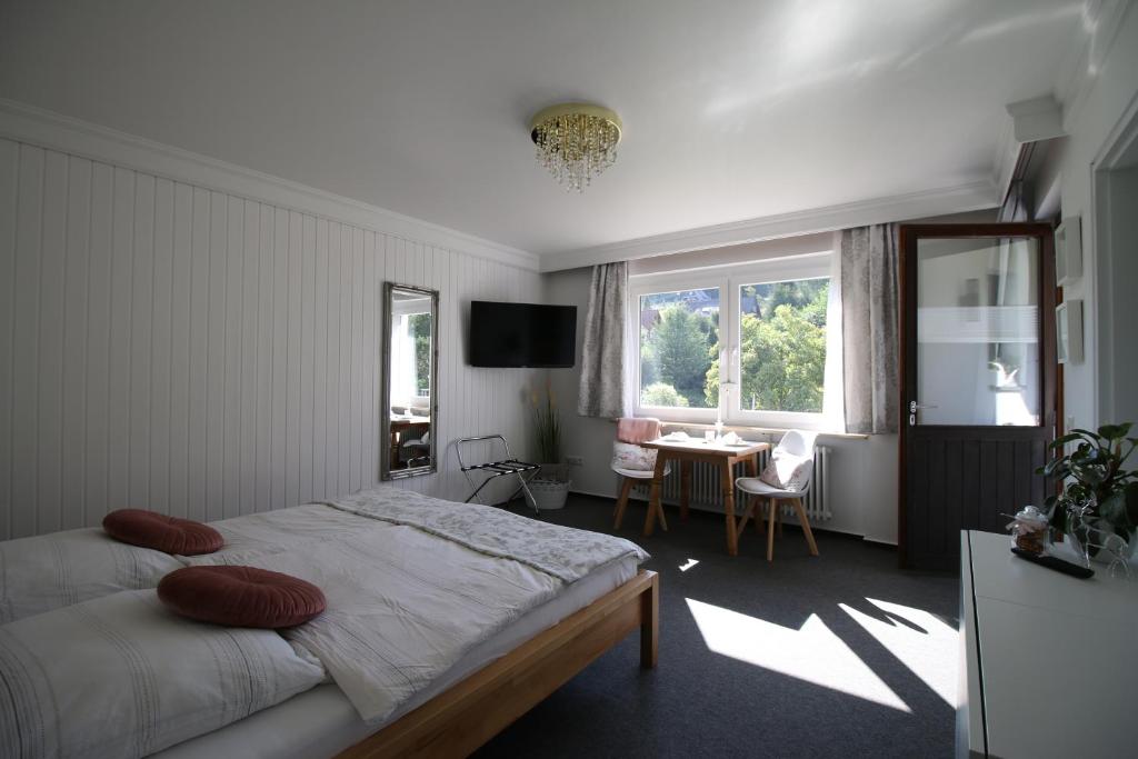 a bedroom with a bed and a table and a window at Haus Anna-Marie in Feldberg