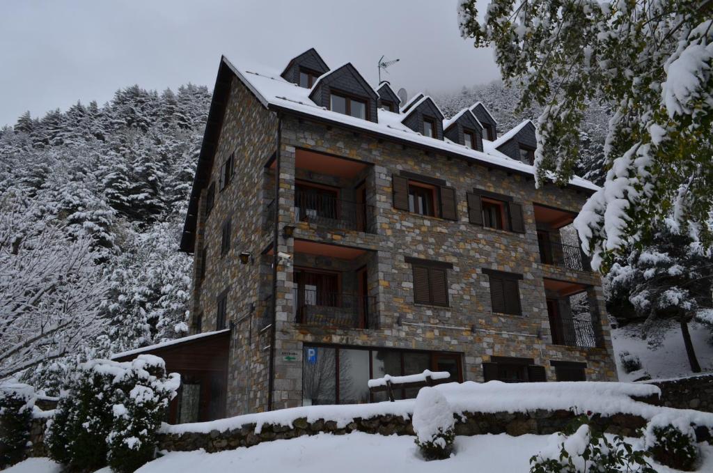 a building with snow on top of it at Apartaments la Peguera in Bohí