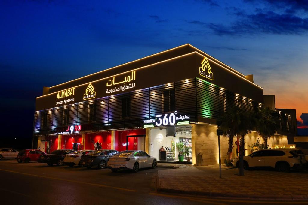 a store with cars parked outside of it at night at شقق المبات للشقق المخدومة in Riyadh