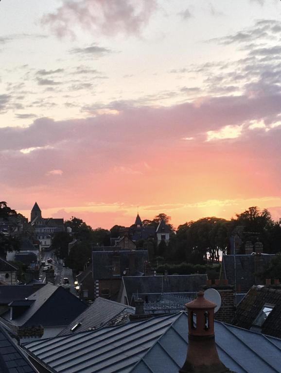 a sunset over the roofs of a city at Le Belvédère de la Baie, grand gîte pour deux in Saint-Valéry-sur-Somme