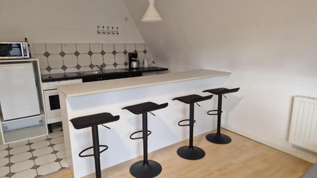 a kitchen with four stools in front of a counter at 2,5 Zimmerwohnung in Mönchengladbach