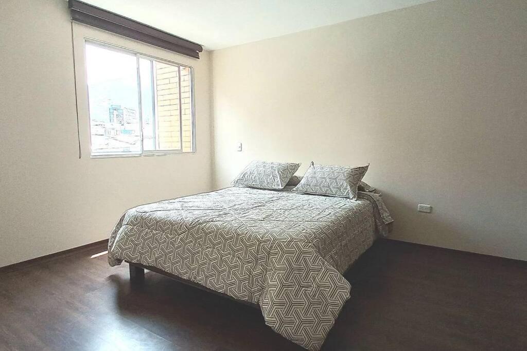 een slaapkamer met een bed en een raam bij La Carolina 202 Bello Departamento in Quito