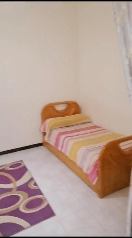 uma pequena cama num quarto com um tapete em Sliceofhaven in Asilah em Asilah