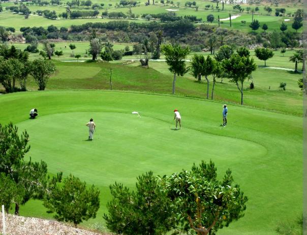 three people playing golf on a golf course at Ático con vistas al mar in Vícar