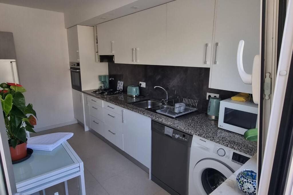 a kitchen with a sink and a washing machine at Apartamento Palomar in Pombal