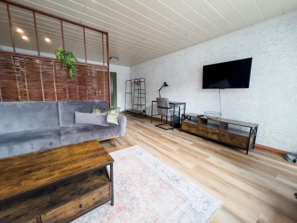 a living room with a couch and a flat screen tv at FeWo Ottobeurens Schmuckstück: Gemütlich-Stylische Wohnung in Ottobeuren