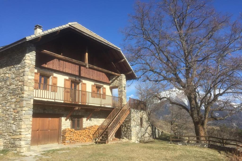 een groot gebouw met een balkon en een boom bij Magnifique maison en balcon sur la Durance in Embrun