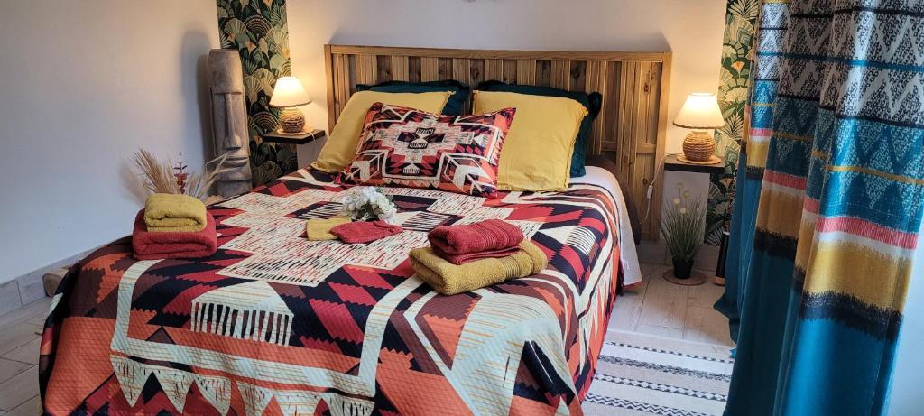 - un lit avec une couverture et des oreillers colorés dans l'établissement Le clos du poète, à Bourges