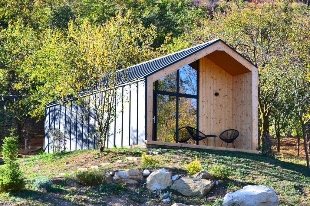 un pequeño cobertizo con una gran ventana en un campo en Tinutul Luanei Village en Bozioru