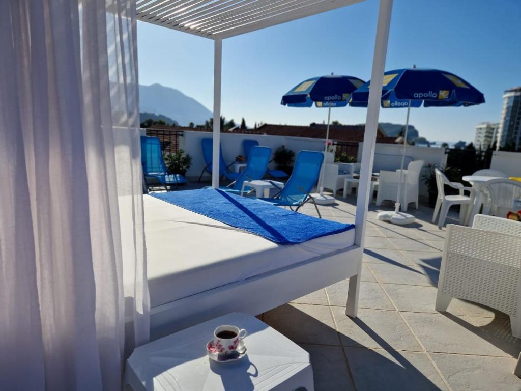 a bed on a rooftop with an umbrella and chairs at Apartments Tamara in Budva