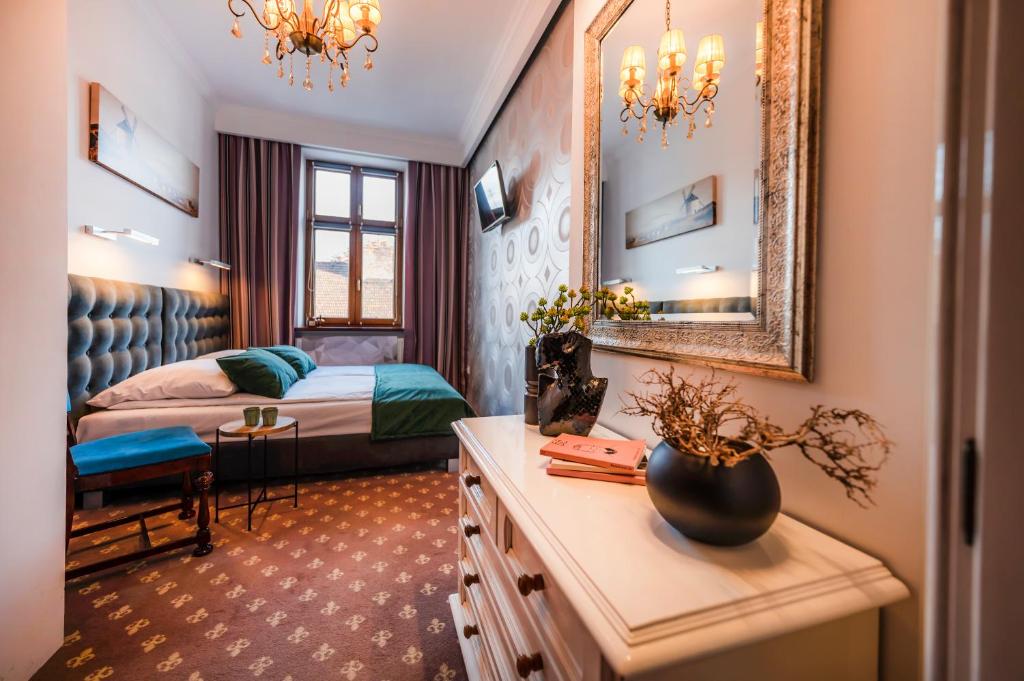 ein Hotelzimmer mit einem Bett und einem Spiegel in der Unterkunft Aparthotel Maargick in Krakau