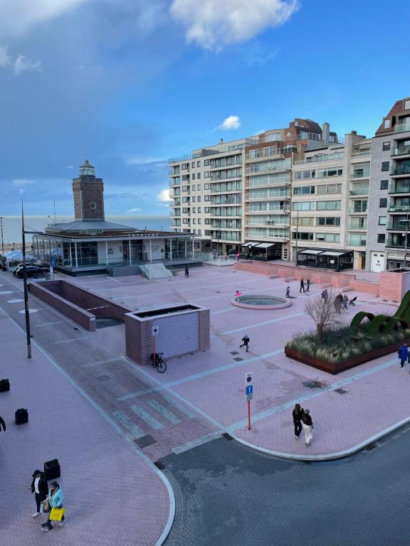 een binnenplaats in een groot gebouw met mensen die rondlopen bij appartement Lichttorenplein met garage in Knokke-Heist