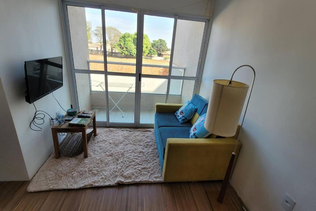 sala de estar con sofá azul y mesa en Apto 02 dormitórios emTatui, en Tatuí