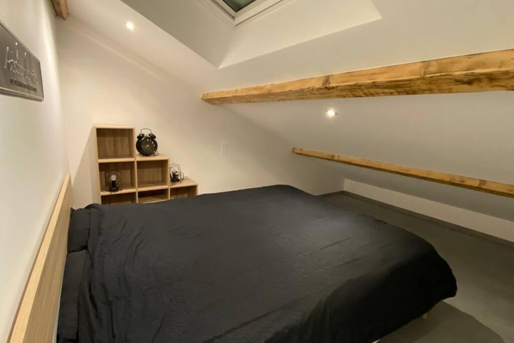- une chambre avec un lit noir dans l'établissement Magnifique T3 Terrasse, Parking!, aux Rousses