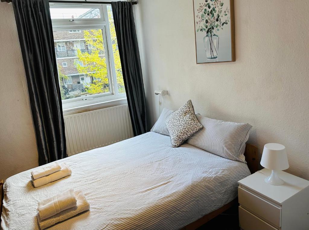 a bedroom with a bed with two towels on it at London City Apartment in London