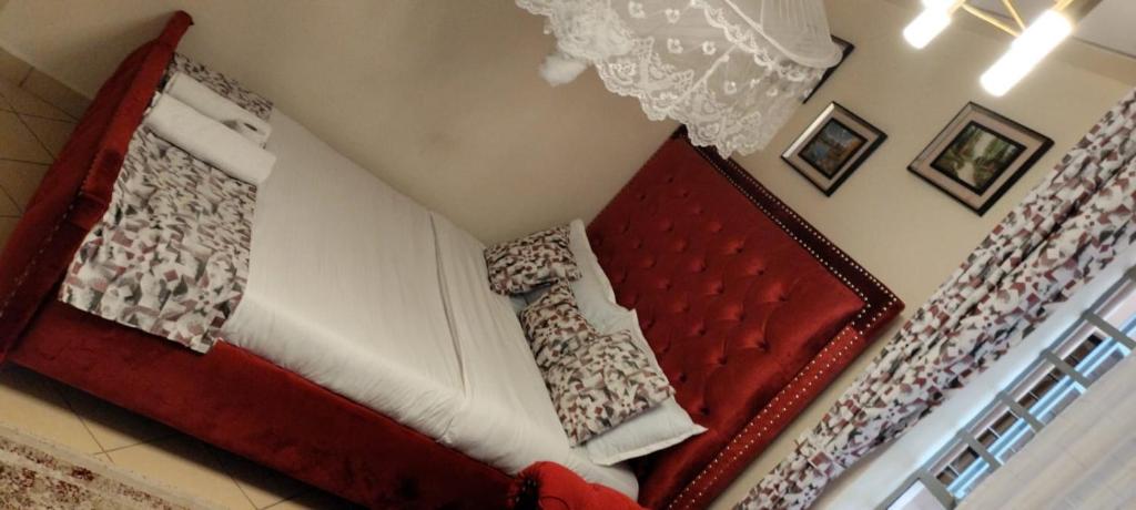 ein rotes und weißes Bett in einem Zimmer in der Unterkunft Soneyhomes in Nairobi