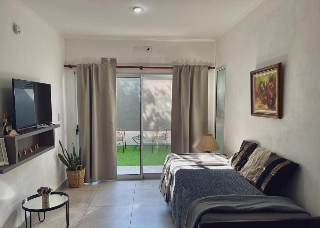 a bedroom with a bed and a sliding glass door at Departamentos Fleming, luminosos p hasta 4 personas in Paraná