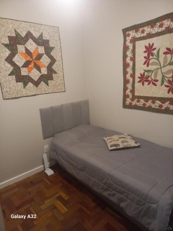 1 dormitorio con 2 camas y edredón en la pared en Apto111consuladoamericano en Porto Alegre