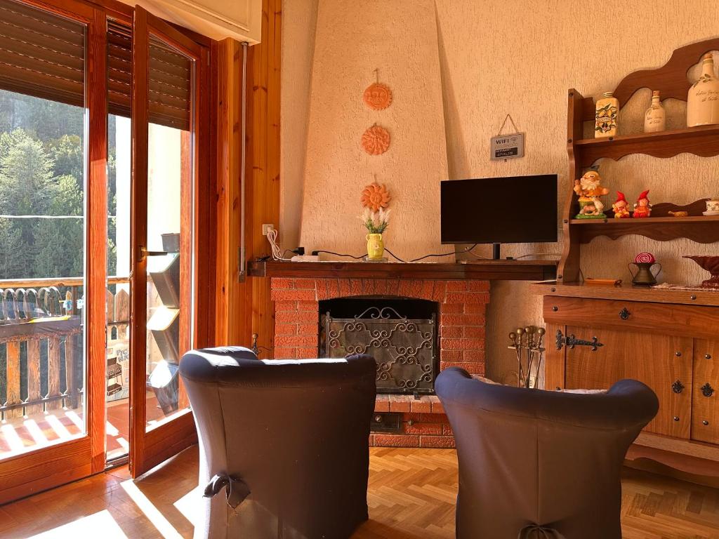 uma sala de estar com duas cadeiras e uma lareira em Roccaraso Love & Lodge - Mountain Chalet em Roccaraso