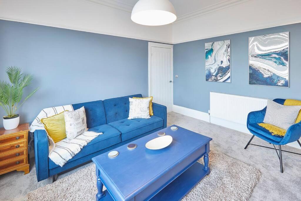 Una sala de estar con un sofá azul y una mesa. en Marshlands, en Redcar