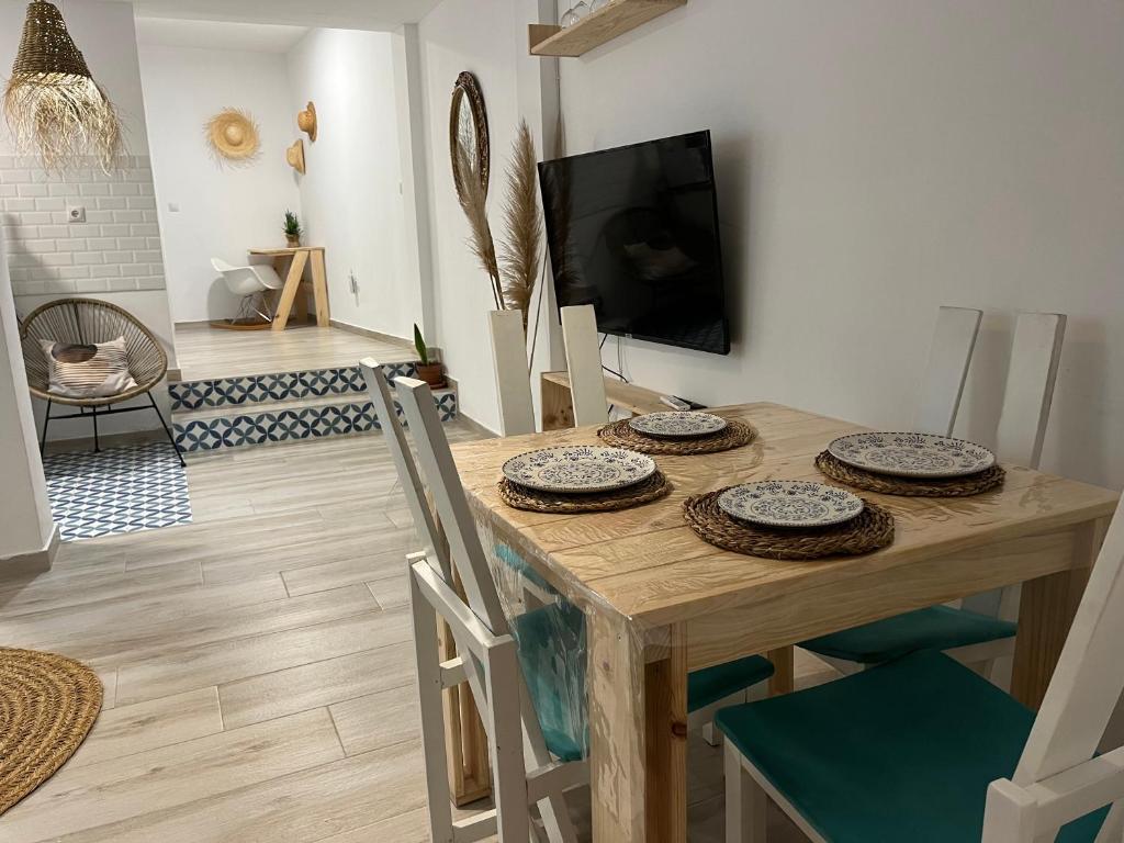 uma sala de jantar com uma mesa com cadeiras e uma televisão em Alzira bonita Apartamento B con patio, la Casella em Alzira