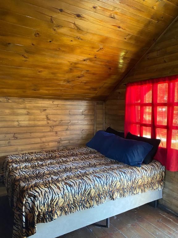 een bed in een kamer met een houten plafond bij Cabanas Route 66 in Santa Vitória do Palmar