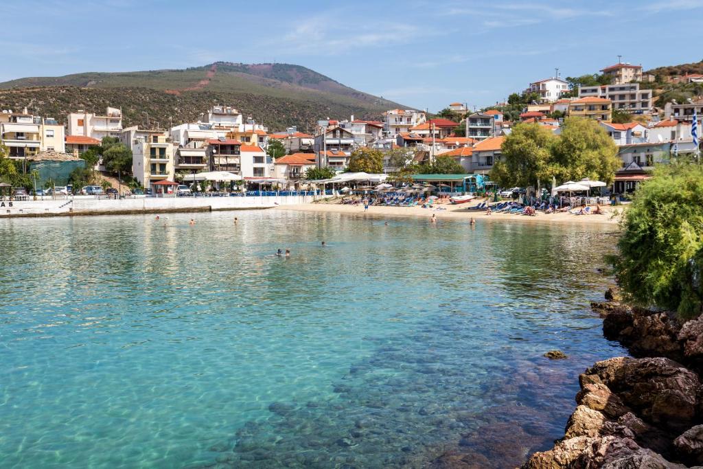 a beach with people swimming in the water at Studios TOUTOULA in Skala Marion