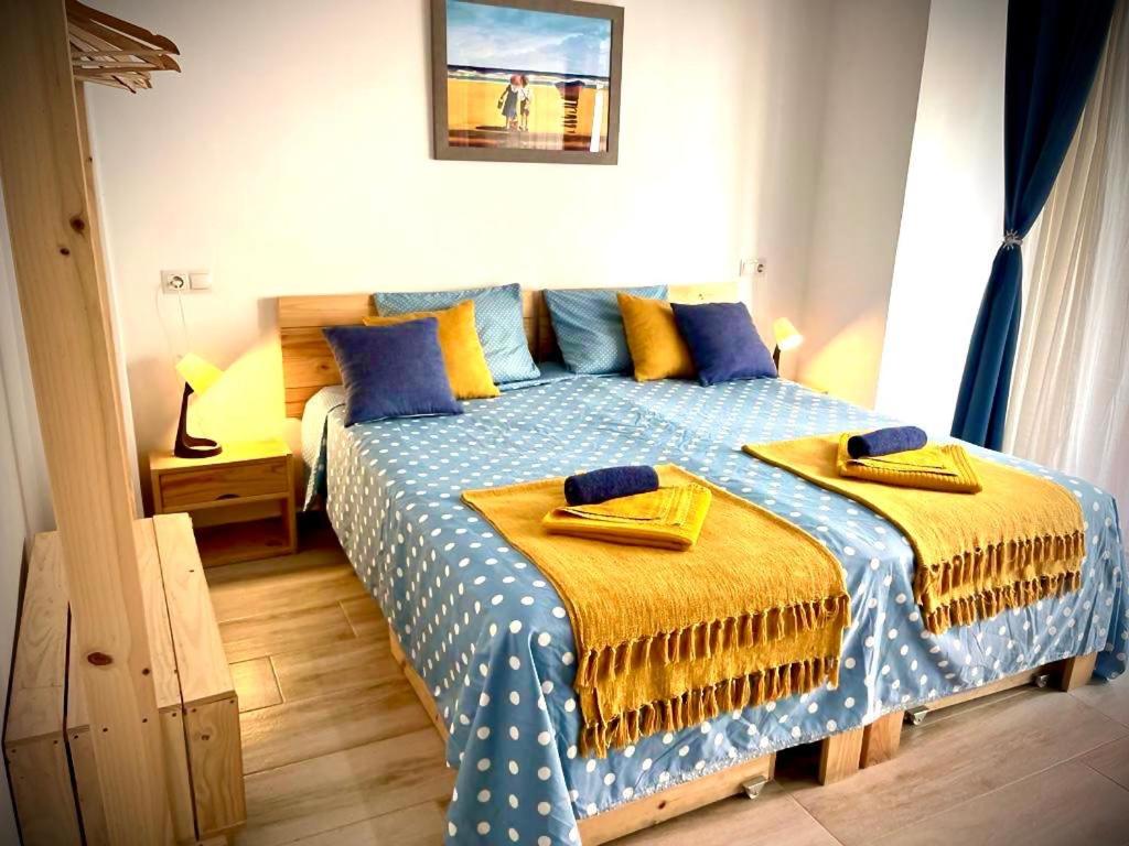 a bedroom with a bed with blue and yellow sheets at Alzira bonita Loft C junto plaza mayor, Les Muralles in Alzira