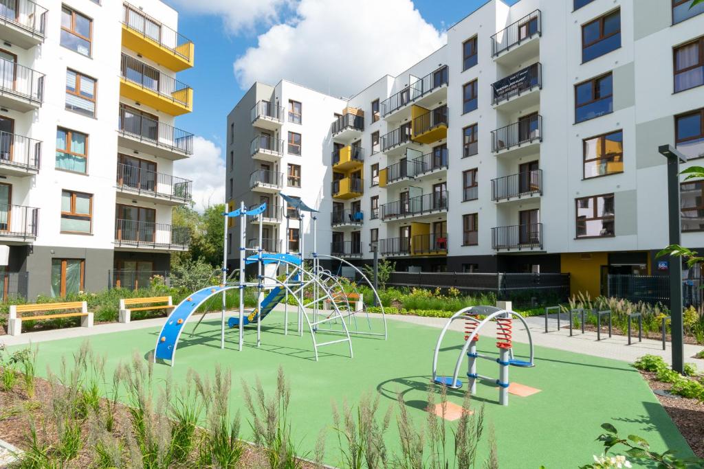 un parque infantil en un complejo de apartamentos con edificios en Platinum Apartments, en Varsovia