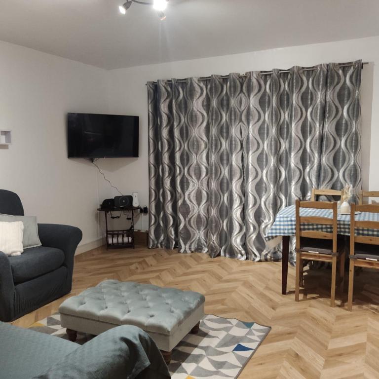 een woonkamer met een bank en een tafel bij Ratcliffe Apartment in Colchester