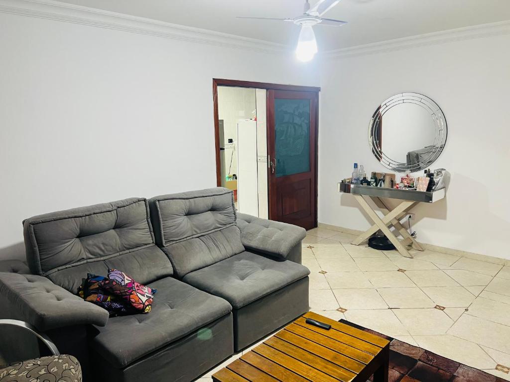 salon z kanapą i lustrem w obiekcie Casa Guaruja w mieście Guarujá