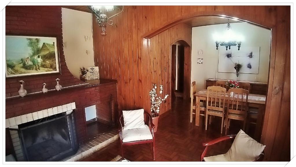 een woonkamer met een open haard en een eetkamer bij Recanto GERMANO in Campos do Jordão