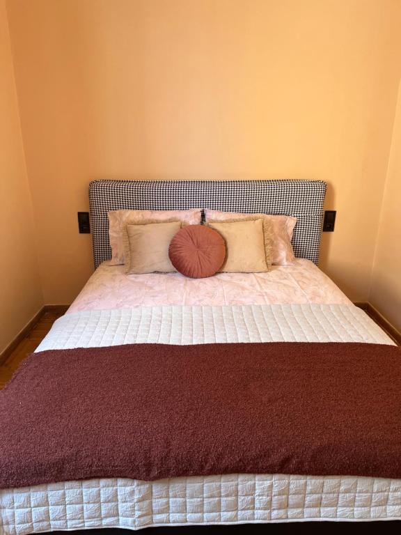 łóżko w pokoju z dużym łóżkiem z poduszkami w obiekcie Retro Apartment Patras w mieście Patras