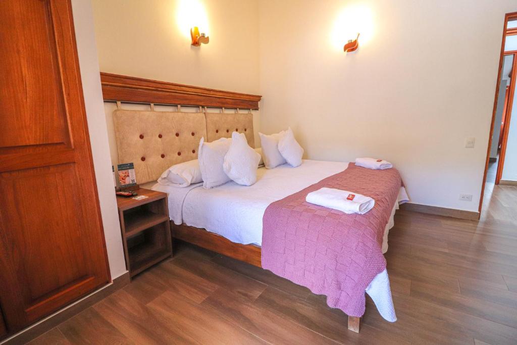 a hotel room with a bed and a table at Hotel las Palmas in Villa de Leyva