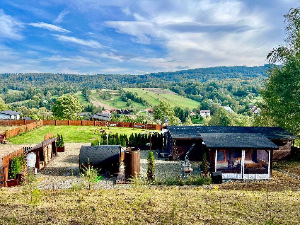 a farm house with a view of the mountains at Bieszczadzka Osada Saunowisko-dom z jacuzzi sauną na wyłączność in Solina