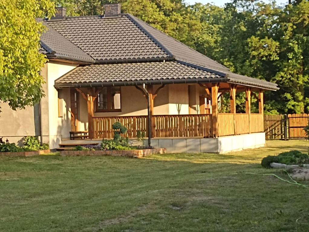 a house with a wooden gazebo in a yard at Dom w Siedlisku pod Orzechem 