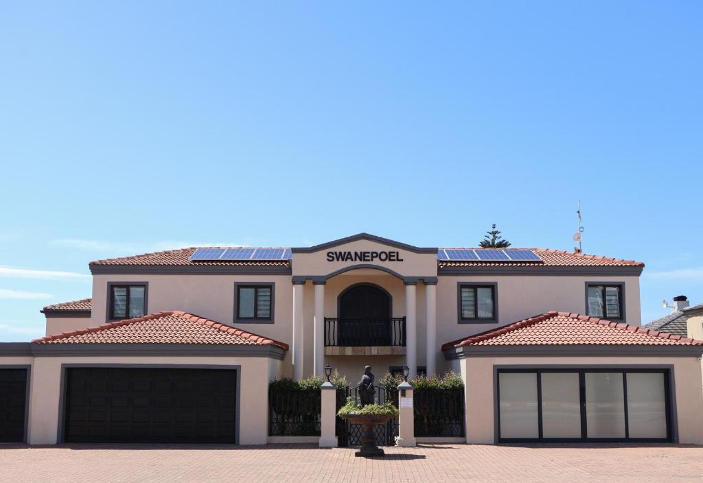 una casa con paneles solares en el techo en Swanepoel Guesthouse & Suites, en Jeffreys Bay