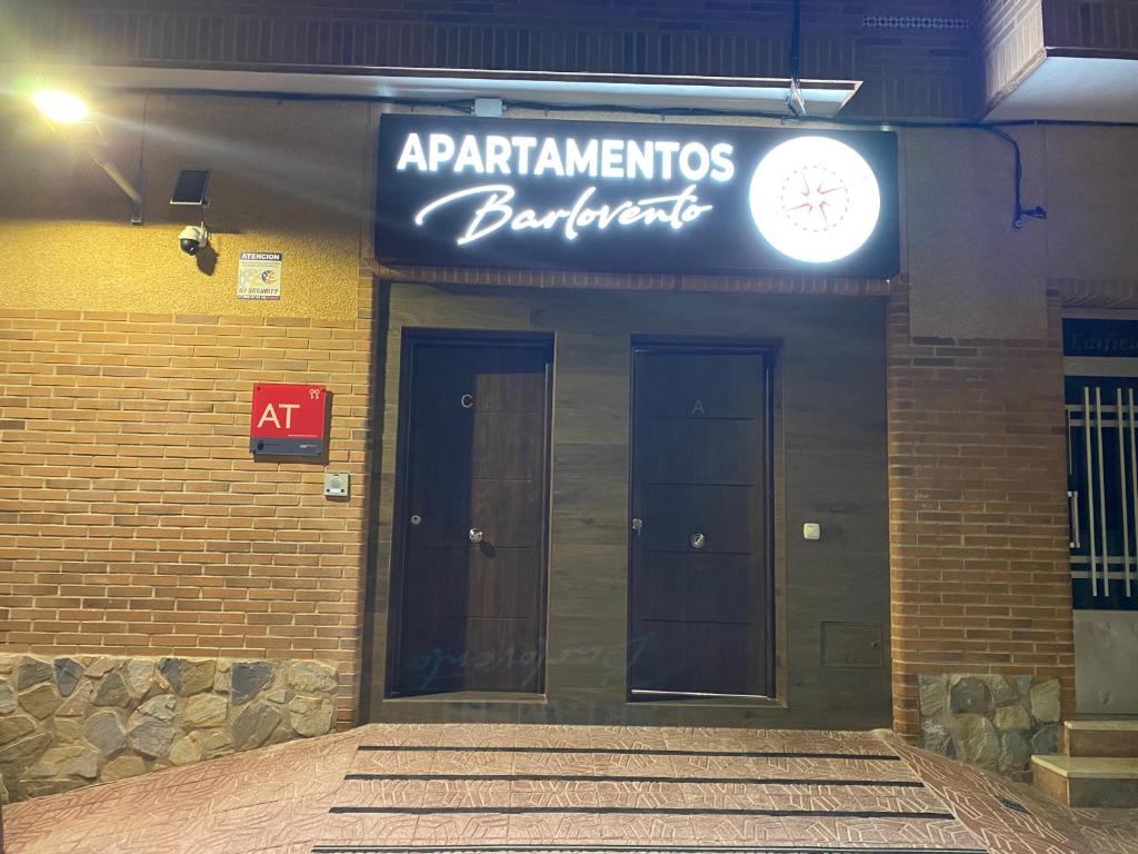 a building with two doors and a sign on it at Apartamentos Barlovento in Puerto de Mazarrón