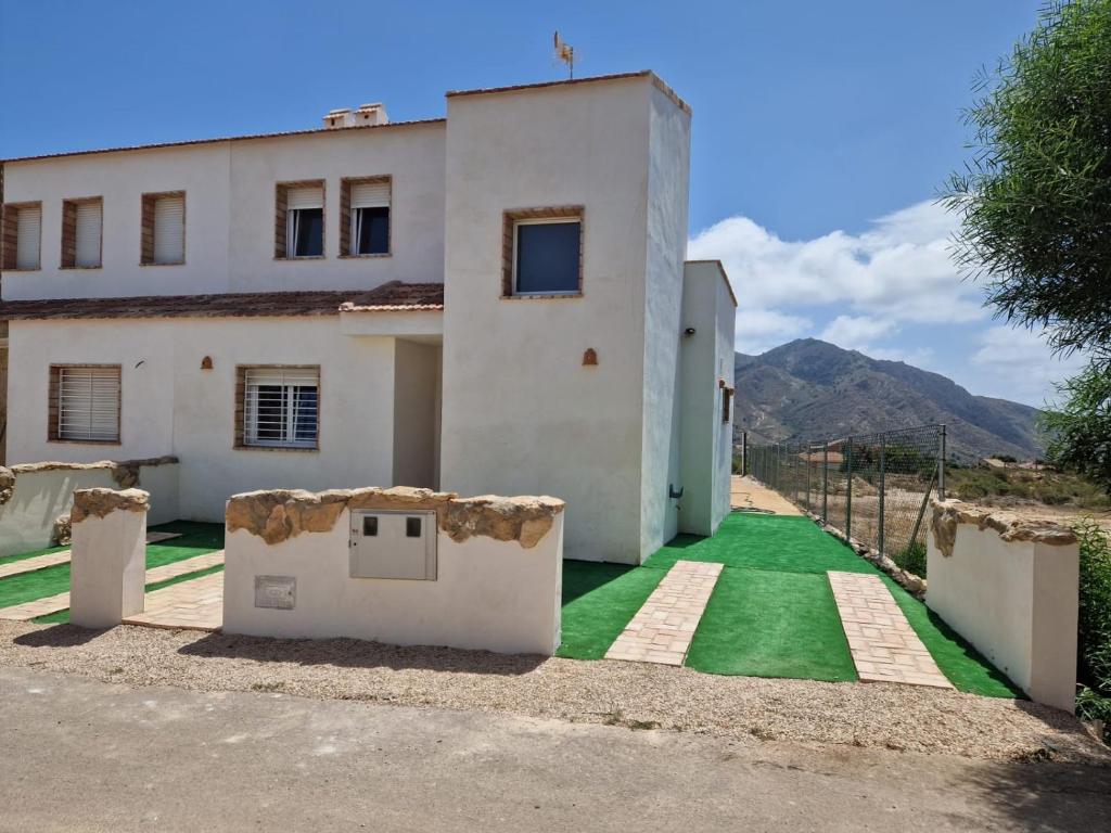 a house with a green lawn in front of it at La bocana del Portús in Cartagena