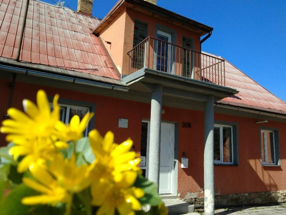 a red house with yellow flowers in front of it at Chata Elča in Lipova Lazne