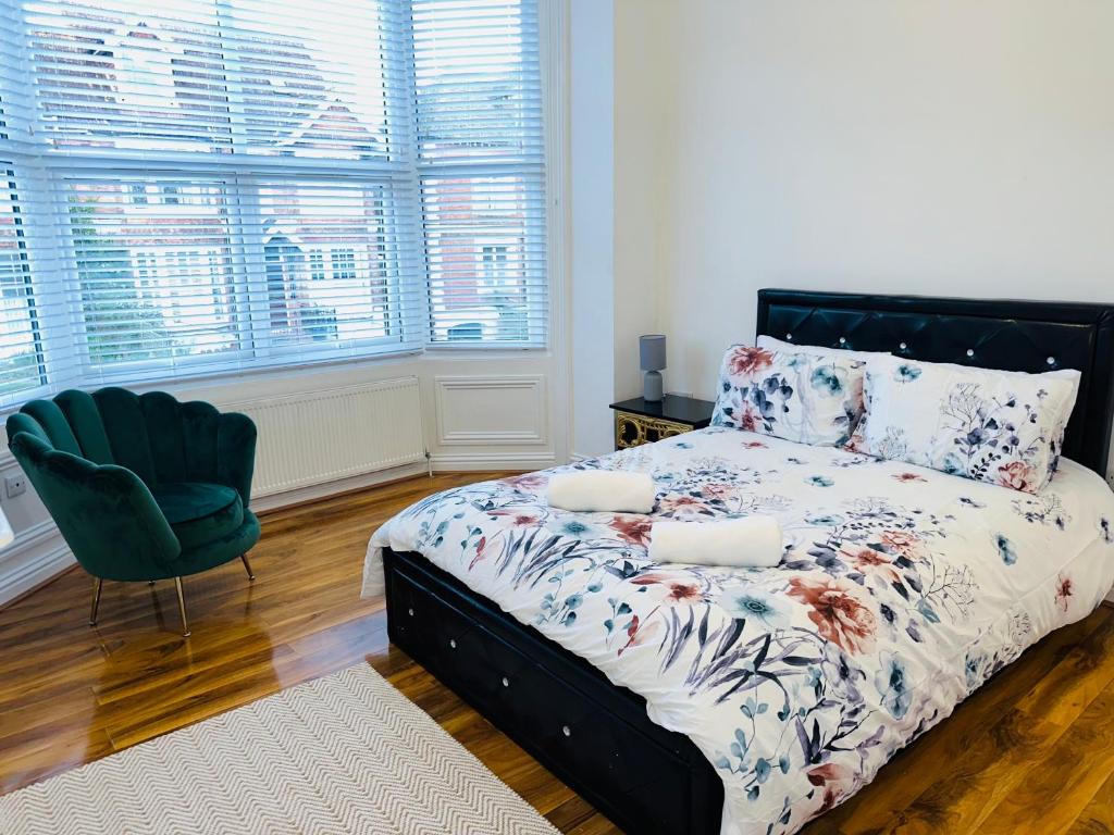 una camera con letto, sedia e finestre di Newly refurbished two bedrooms flat a St Leonards