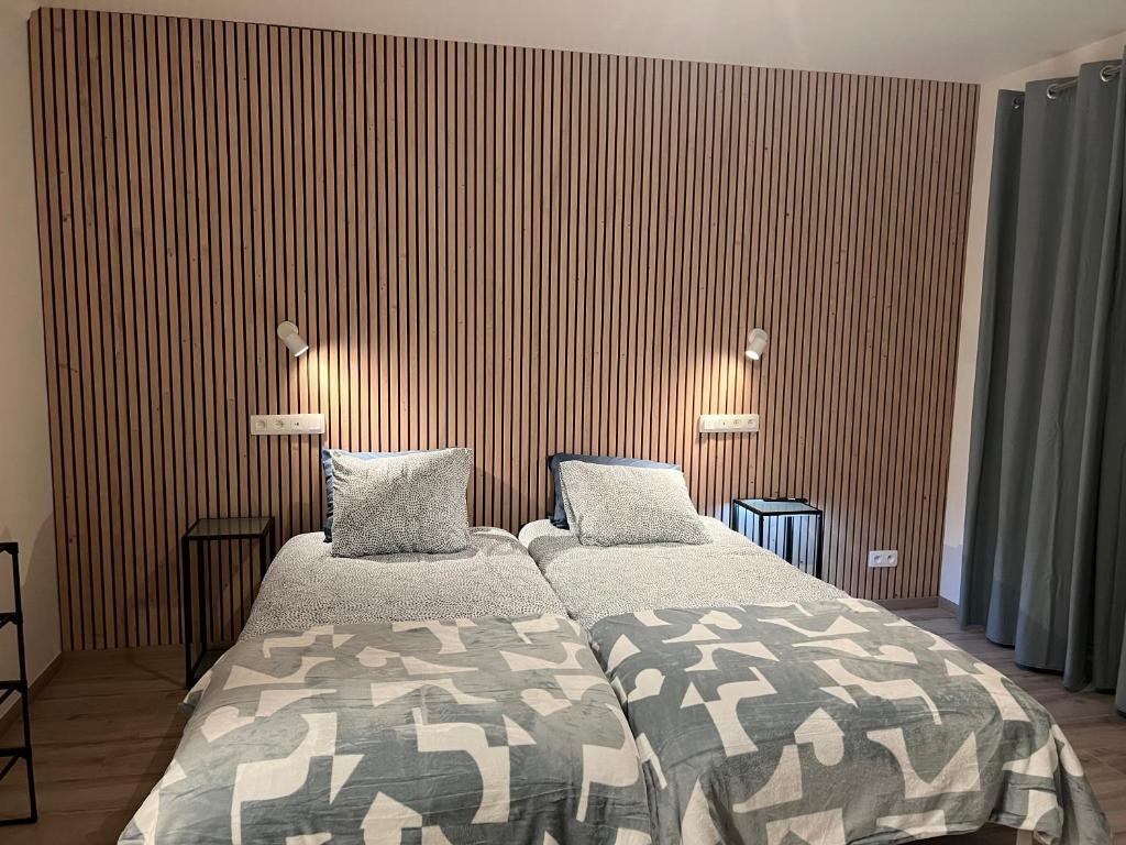 2 camas en una habitación con paredes a rayas en Blue Cottage Bruxelles Sud, en Wavre