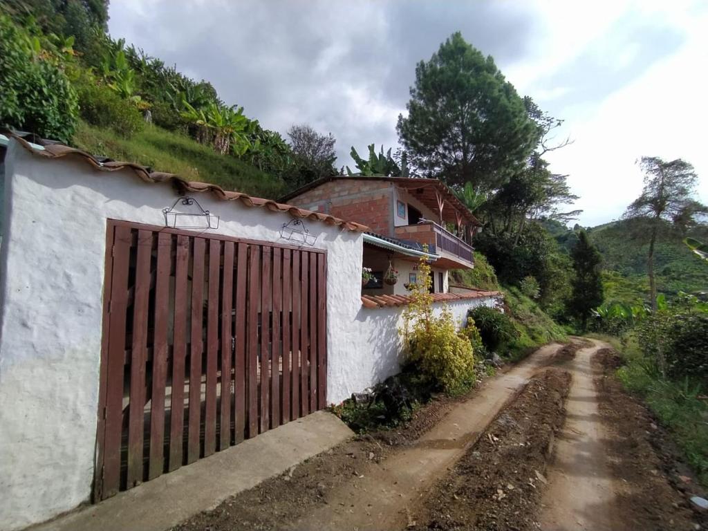 a house with a gate on the side of a dirt road at Alojamiento en Jardin Cabaña las Aguilas in Jardin
