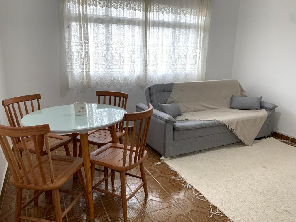 a living room with a couch and a table and chairs at Apartamento Vista Mar in Peruíbe