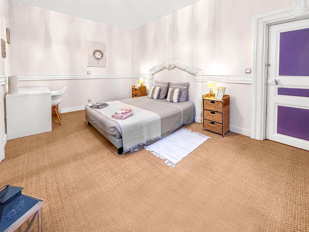 - une chambre blanche avec un lit et un bureau dans l'établissement Les Portes du Château Beaucairois, à Beaucaire